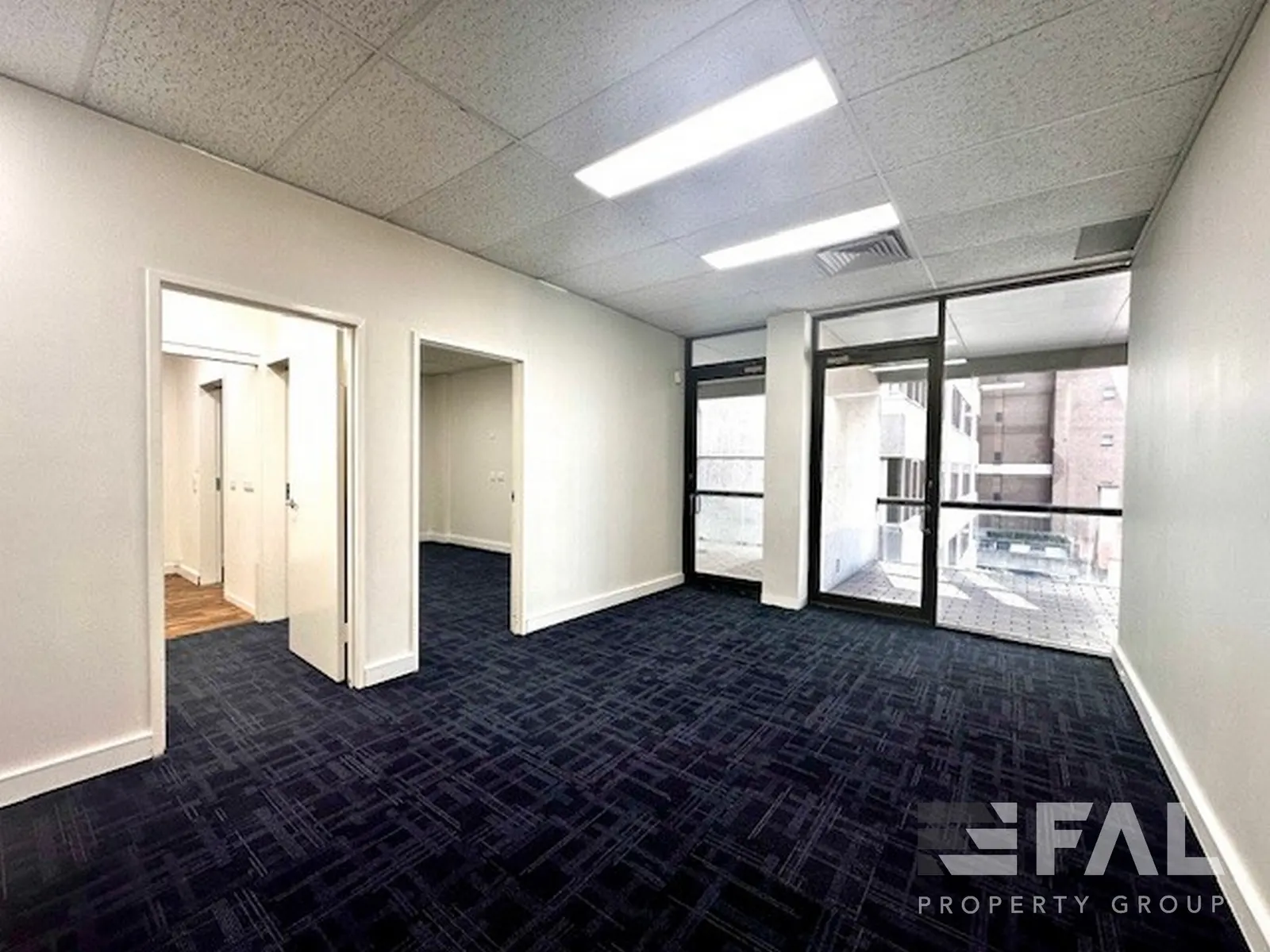 Naturally lit fitted office with doors opening towards a balcony